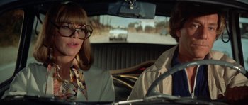 Movie still from “A Touch of Class” (1973), directed by Melvin Frank – A woman and a man sitting in the back seat of a car; Close Up shot, Low angle