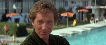 Movie still from “A Touch of Class” (1973), directed by Melvin Frank – A person wearing a robe near a swimming pool; Close Up shot, Low angle