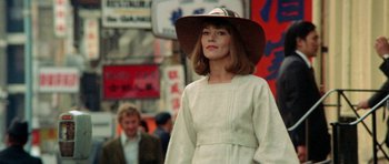Movie still from “A Touch of Class” (1973), directed by Melvin Frank – A woman wearing a white dress and a brown hat; Close Up shot, Low angle