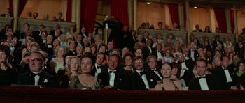 Movie still from “A Touch of Class” (1973), directed by Melvin Frank – A group of people sitting in a theater wearing tuxedos; Wide shot, High angle