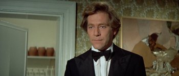 Movie still from “A Touch of Class” (1973), directed by Melvin Frank – A person wearing a suit and bow tie; Close Up shot, Low angle
