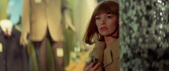Movie still from “A Touch of Class” (1973), directed by Melvin Frank – A woman holding a bottle in front of a mirror; Close Up shot, Over the shoulder angle