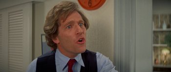 Movie still from “A Touch of Class” (1973), directed by Melvin Frank – A person wearing a suit and tie; Close Up shot, Low angle