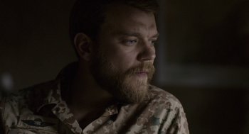 Movie still from “A War” (2015), directed by Tobias Lindholm – A man with a goatee is looking at the camera; Close Up shot, Over the shoulder angle