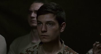 Movie still from “A War” (2015), directed by Tobias Lindholm – A man in military fatigues looking at the camera; Close Up shot, Over the shoulder angle