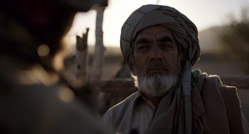Movie still from “A War” (2015), directed by Tobias Lindholm – An old man with a beard wearing a turban; Close Up shot, Over the shoulder angle