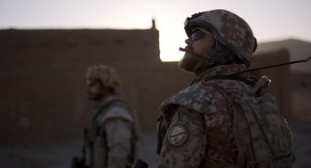 Movie still from “A War” (2015), directed by Tobias Lindholm – Two men in military uniforms standing next to each other; Medium shot, Over the shoulder angle