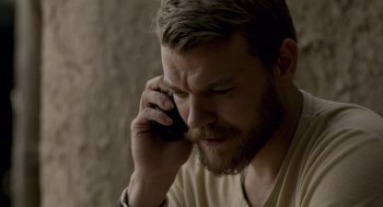 Movie still from “A War” (2015), directed by Tobias Lindholm – A man with a beard is talking on a cell phone; Close Up shot, Low angle