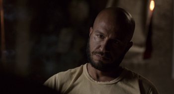 Movie still from “A War” (2015), directed by Tobias Lindholm – A man with a bald head is looking at the camera; Close Up shot, Over the shoulder angle