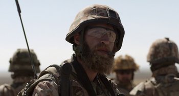 Movie still from “A War” (2015), directed by Tobias Lindholm – A man with a beard wearing a helmet and glasses; Close Up shot, Over the shoulder angle