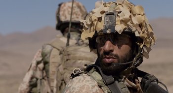 Movie still from “A War” (2015), directed by Tobias Lindholm – A person wearing a helmet; Close Up shot, Over the shoulder angle