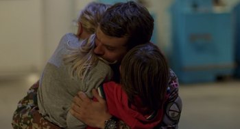 Movie still from “A War” (2015), directed by Tobias Lindholm – A man is hugging two children in a room; Close Up shot, Over the shoulder angle