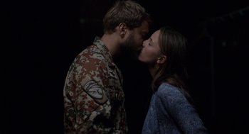 Movie still from “A War” (2015), directed by Tobias Lindholm – A man and a woman kissing in a dark room; Medium shot, Over the shoulder angle