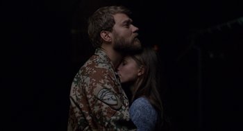 Movie still from “A War” (2015), directed by Tobias Lindholm – A man and a woman are hugging in the dark; Close Up shot, Low angle