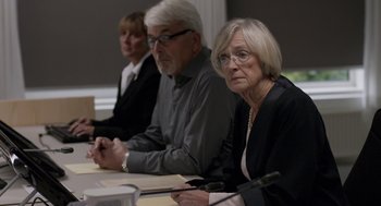 Movie still from “A War” (2015), directed by Tobias Lindholm – A group of people sitting around a table; Medium shot, Over the shoulder angle