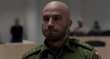 Movie still from “A War” (2015), directed by Tobias Lindholm – A man with a bald head wearing a green uniform; Close Up shot, Over the shoulder angle