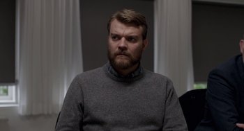 Movie still from “A War” (2015), directed by Tobias Lindholm – A man with a beard and a gray sweater; Close Up shot, Over the shoulder angle
