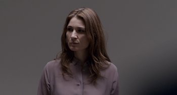 Movie still from “A War” (2015), directed by Tobias Lindholm – A woman with long brown hair is wearing a purple shirt; Close Up shot, Over the shoulder angle