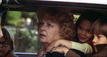 Movie still from “A Woman Under the Influence” (1974), directed by John Cassavetes – An older woman is sitting in the back of a car with a younger woman; Close Up shot, Over the shoulder angle