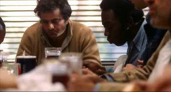 Movie still from “A Woman Under the Influence” (1974), directed by John Cassavetes – A group of people sitting at a table with drinks; Close Up shot, Over the shoulder angle
