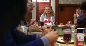 Movie still from “A Woman Under the Influence” (1974), directed by John Cassavetes – A group of people sitting around a table eating food; Medium shot, Over the shoulder angle