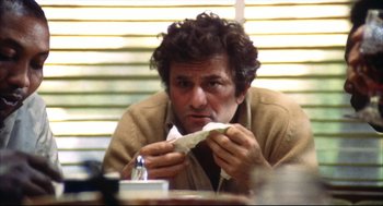 Movie still from “A Woman Under the Influence” (1974), directed by John Cassavetes – A man sitting at a table with a sandwich in front of him; Close Up shot, Low angle