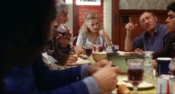 Movie still from “A Woman Under the Influence” (1974), directed by John Cassavetes – A group of people sitting around a table eating; Medium shot, Over the shoulder angle