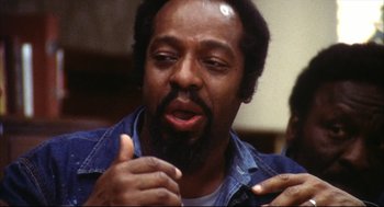 Movie still from “A Woman Under the Influence” (1974), directed by John Cassavetes – A man with a beard is talking to a crowd; Close Up shot, Low angle