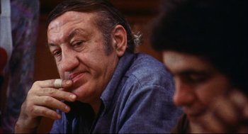 Movie still from “A Woman Under the Influence” (1974), directed by John Cassavetes – An older man sitting in front of another older man; Close Up shot, Low angle