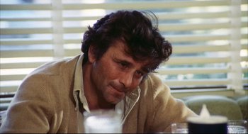 Movie still from “A Woman Under the Influence” (1974), directed by John Cassavetes – A person sitting at a table; Close Up shot, Over the shoulder angle