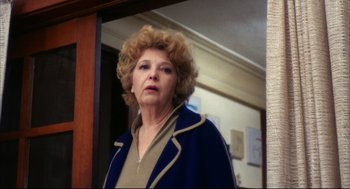 Movie still from “A Woman Under the Influence” (1974), directed by John Cassavetes – An older woman standing in front of a mirror; Close Up shot, Low angle
