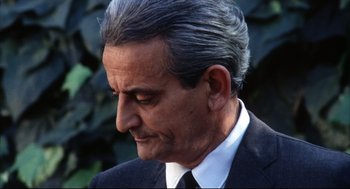 Movie still from “A Woman Under the Influence” (1974), directed by John Cassavetes – An older man in a black suit and white tie; Close Up shot, Low angle
