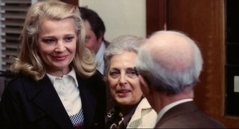Movie still from “A Woman Under the Influence” (1974), directed by John Cassavetes – Two women and a man are talking to each other; Medium shot, Low angle