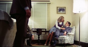 Movie still from “A Woman Under the Influence” (1974), directed by John Cassavetes – A man and a woman sitting on a couch; Wide shot, High angle