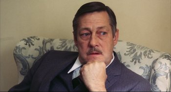 Movie still from “A Woman Under the Influence” (1974), directed by John Cassavetes – A person wearing a suit and tie; Close Up shot, High angle