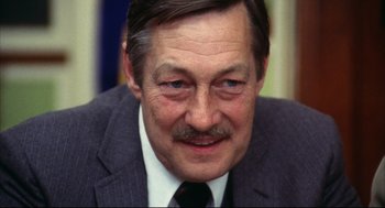 Movie still from “A Woman Under the Influence” (1974), directed by John Cassavetes – A person wearing a suit and tie; Close Up shot, High angle