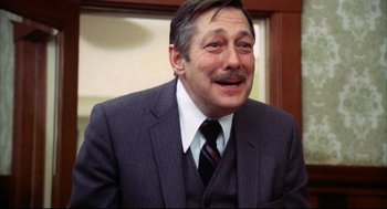 Movie still from “A Woman Under the Influence” (1974), directed by John Cassavetes – A person wearing a suit and tie; Close Up shot, Low angle