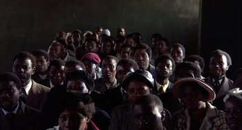 A large group of people sitting in front of a projector screen