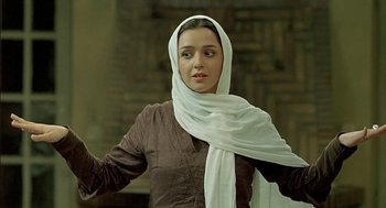 Movie still from “About Elly” (2009), directed by Asghar Farhadi – A woman with a white headscarf is posing for a picture; Medium shot, Low angle