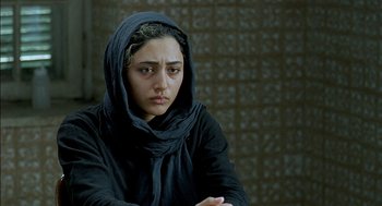 Movie still from “About Elly” (2009), directed by Asghar Farhadi – A woman in a black hooded sweatshirt looking at the camera; Close Up shot, Over the shoulder angle