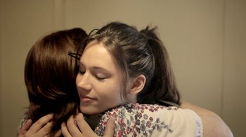 Movie still from “Absentia” (2011), directed by Mike Flanagan – Two young women hugging each other in a room; Close Up shot, Over the shoulder angle