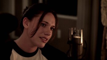 Movie still from “Absentia” (2011), directed by Mike Flanagan – A young woman sitting in front of a microphone in a room; Close Up shot, Over the shoulder angle