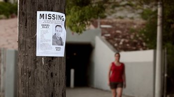 Movie still from “Absentia” (2011), directed by Mike Flanagan – A missing person poster hanging on a pole; Wide shot, Low angle