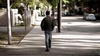 Movie still from “Absentia” (2011), directed by Mike Flanagan – A man walking down a sidewalk on a sunny day; Wide shot, Low angle