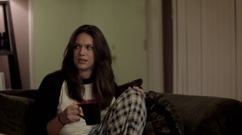 Movie still from “Absentia” (2011), directed by Mike Flanagan – A woman sitting on a couch holding a coffee mug; Medium shot, Over the shoulder angle