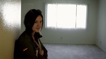 Movie still from “Absentia” (2011), directed by Mike Flanagan – A woman standing in front of a window in a room; Medium shot, Low angle