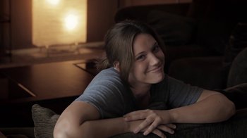 Movie still from “Absentia” (2011), directed by Mike Flanagan – A woman smiles while sitting on a couch; Close Up shot, Over the shoulder angle