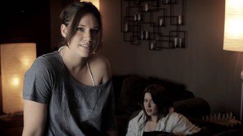 Movie still from “Absentia” (2011), directed by Mike Flanagan – Two women sitting on a couch in a living room; Medium shot, Over the shoulder angle