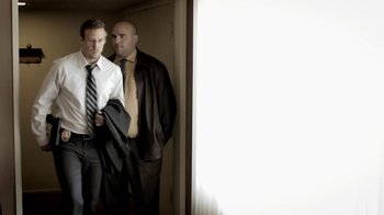 Movie still from “Absentia” (2011), directed by Mike Flanagan – Two men standing in front of a window; Medium shot, Low angle