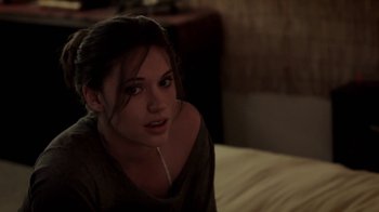 Movie still from “Absentia” (2011), directed by Mike Flanagan – A woman sitting on a bed looking at the camera; Close Up shot, Over the shoulder angle